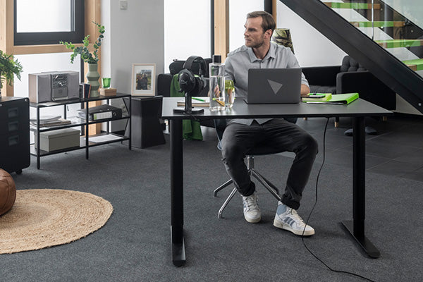 Mann arbeitet mit Laptop am Yaasa Desk Basic S