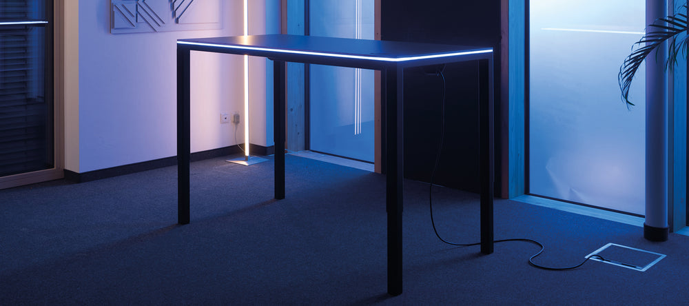 Dunkelgrauer höhenverstellbarer Tisch Yaasa Desk Four mit LED-Lichtstreifen.