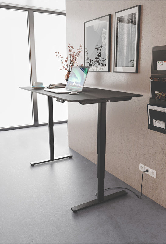 Höhenverstellbarer Schreibtisch zusammengestellt aus Yaasa Desk Frame und schwarzer Tischplatte.