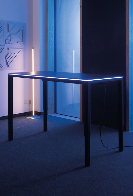 Dunkelgrauer Tisch Yaasa Desk Four mit smarter LED-Tischbeleuchtung.