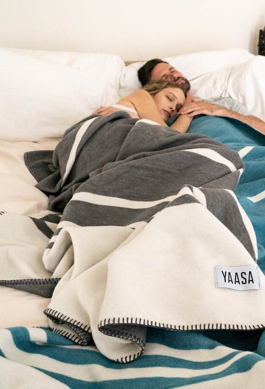 Mann und Frau schlafen zugedeckt mit Yaasa Elements Blanket.