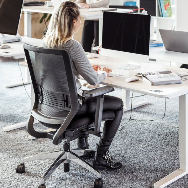 Frau sitzt aufrecht und ergonomisch auf dem schwarzen Yaasa Chair.